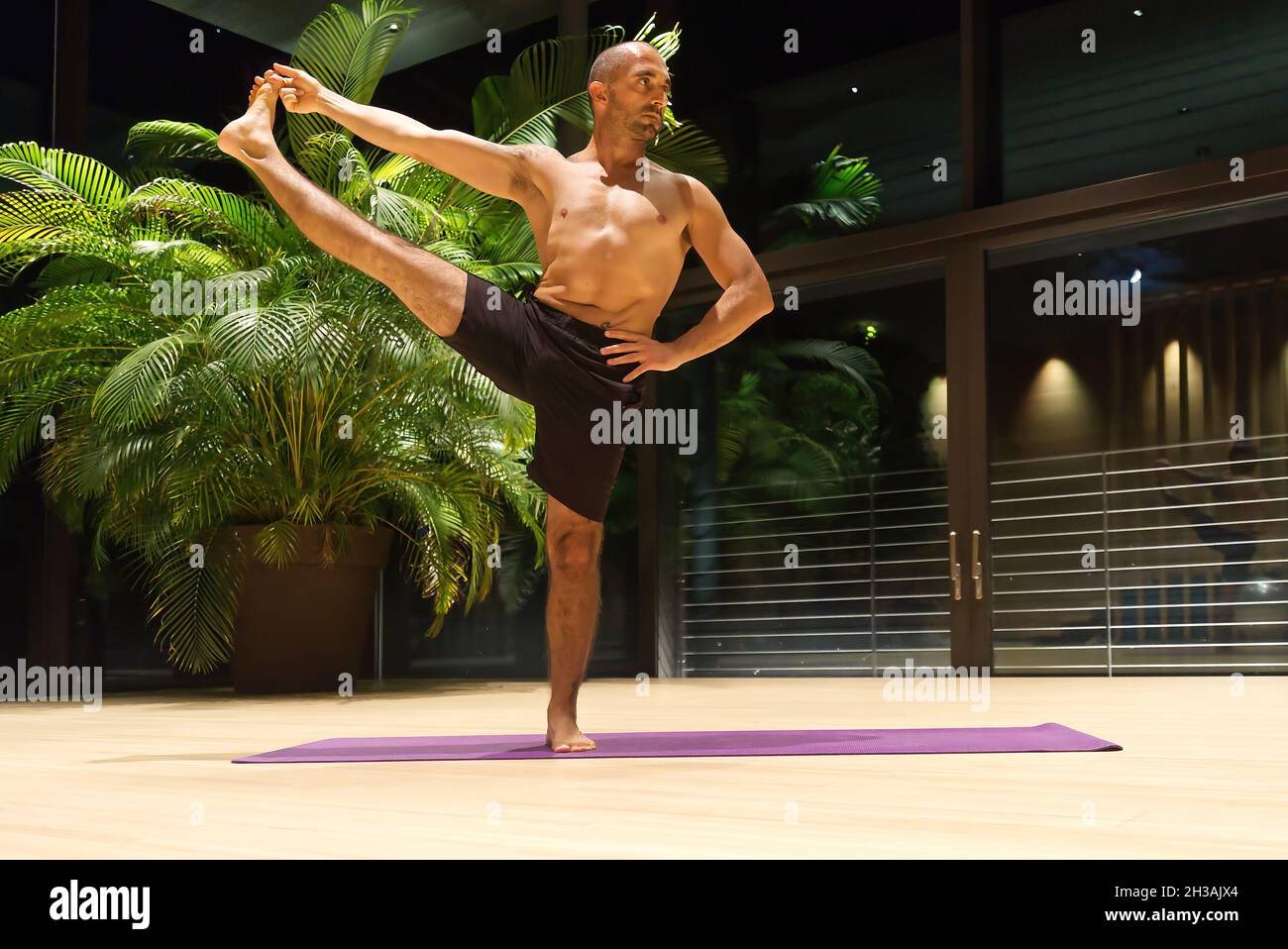Omar Mura Mann mittleren Alters kaukasischen führt eine Yoga-Position in Innenräumen. Stockfoto