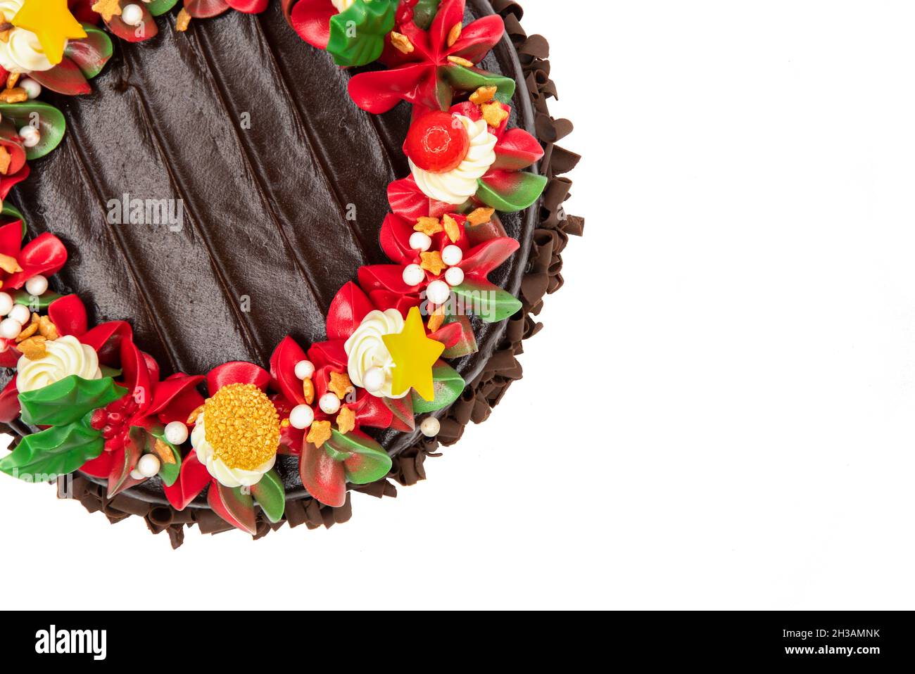 Draufsicht auf einen Schokoladenkuchen mit roten, weißen und grünen Blumen und Blättern. Stockfoto