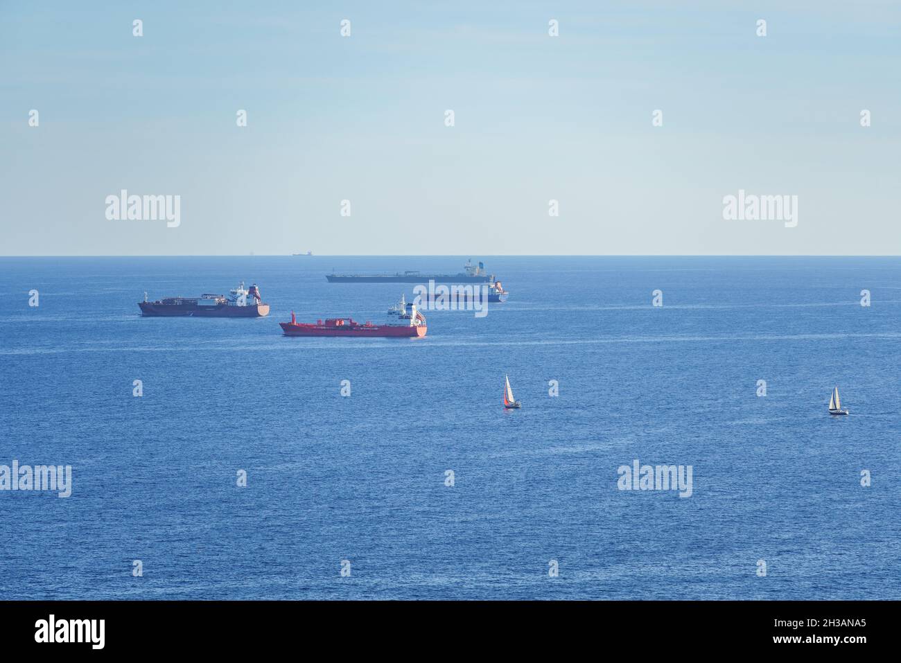 Frachtschiffe Frachter vor Anker am Mittelmeer und Segelboote segeln Stockfoto