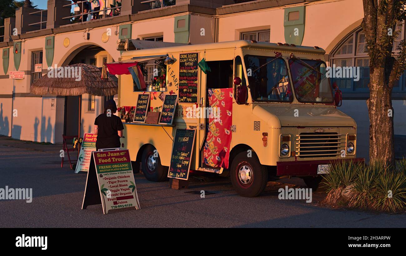 Blick auf den San Juan Food Truck, der bolivanische Bio-Mahlzeiten an Fußgänger am English Bay Beach im West End, Vancouver Downtown, im Abendlicht verkauft. Stockfoto