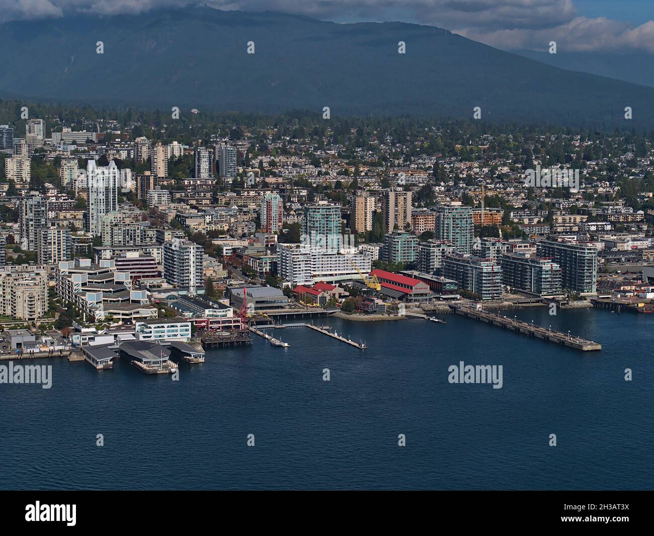 Luftaufnahme von North Vancouver mit den Werften im Bezirk Lower Lonsdale mit Küste, Wohngebäuden und Bergen im Hintergrund. Stockfoto