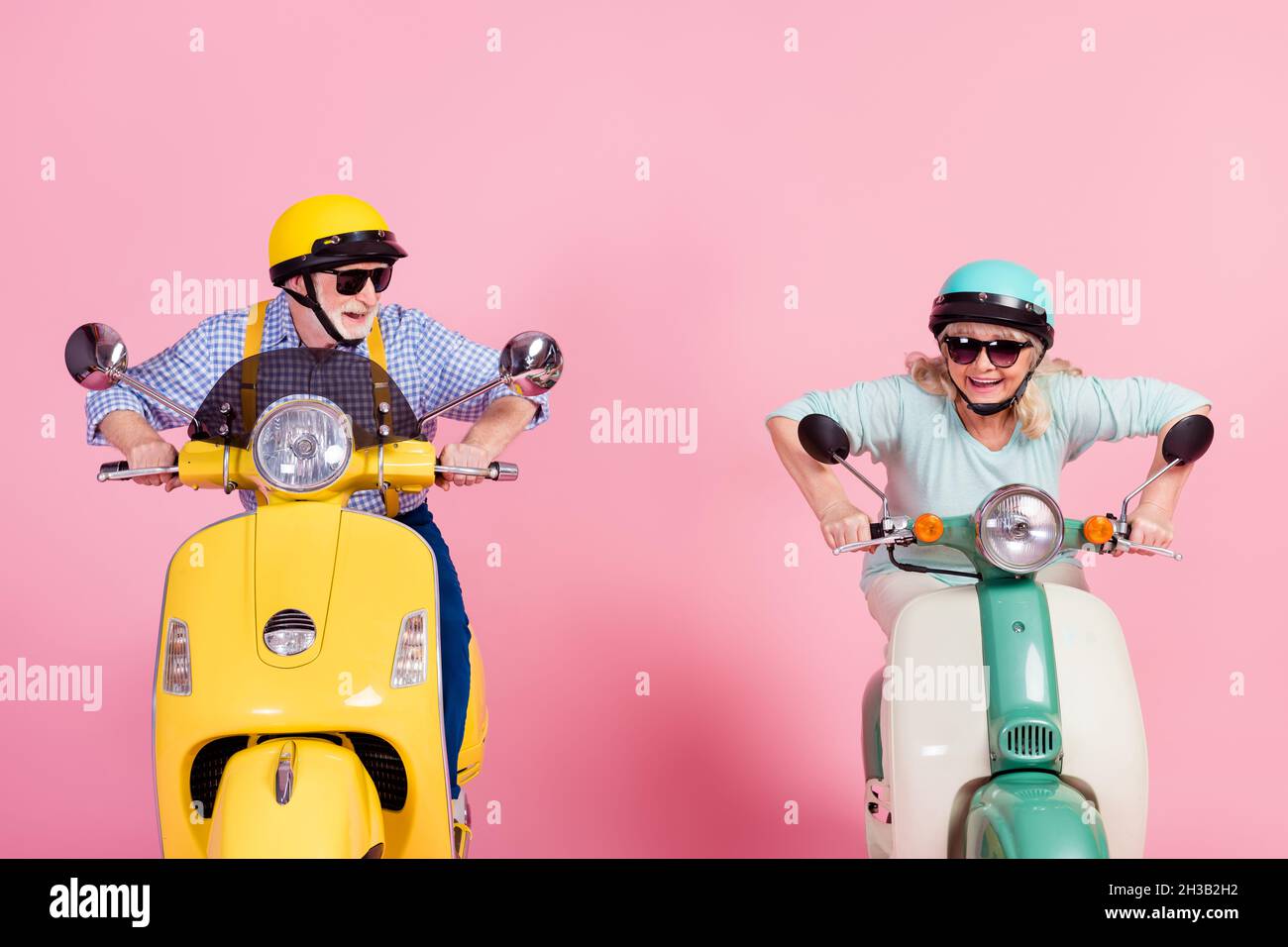 Foto von aufgeregt funky Senior Mann Frau fahren Motorrad gekleidet Helme Brille eilen isoliert rosa Hintergrund Stockfoto