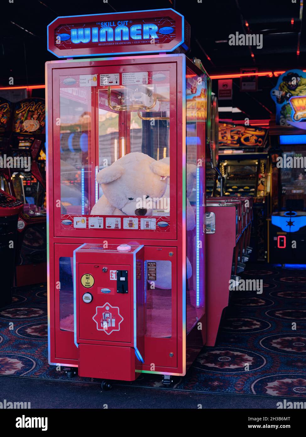 Kein Gewinner - Ein trauriger großer, weißer, kuscheliger Teddybär, der in einem Arcade-Spiel am Meer steckt - kein Glück Stockfoto