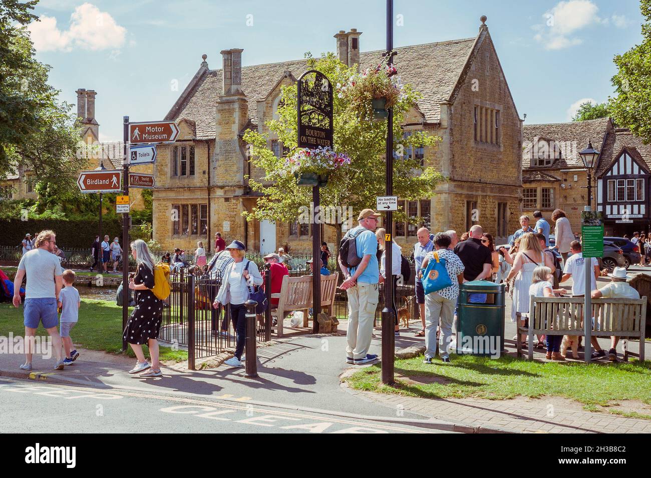 Massen von Besuchern genießen einen sonnigen Tag in Bourton on the Water, einem malerischen Dorf in den Cotswolds, Großbritannien. Stockfoto