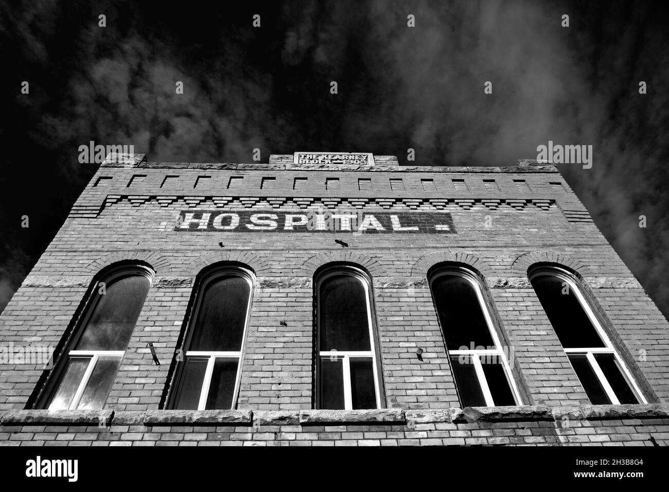 Altes Klinikgebäude aus Ziegelsteinen, alte medizinische Einrichtung mit blauem Himmel und Wolken Stockfoto