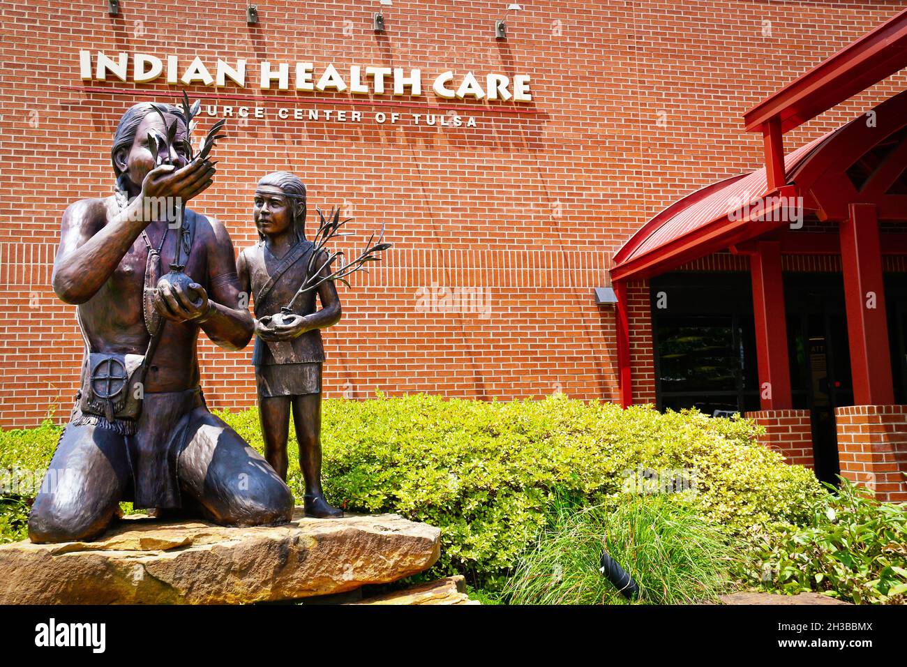07-20-2021 Tulsa OK USA Statuen von indischen Männern und Kindern, die Bäume vor dem indischen Gesundheitszentrum Pflanzen. Stockfoto