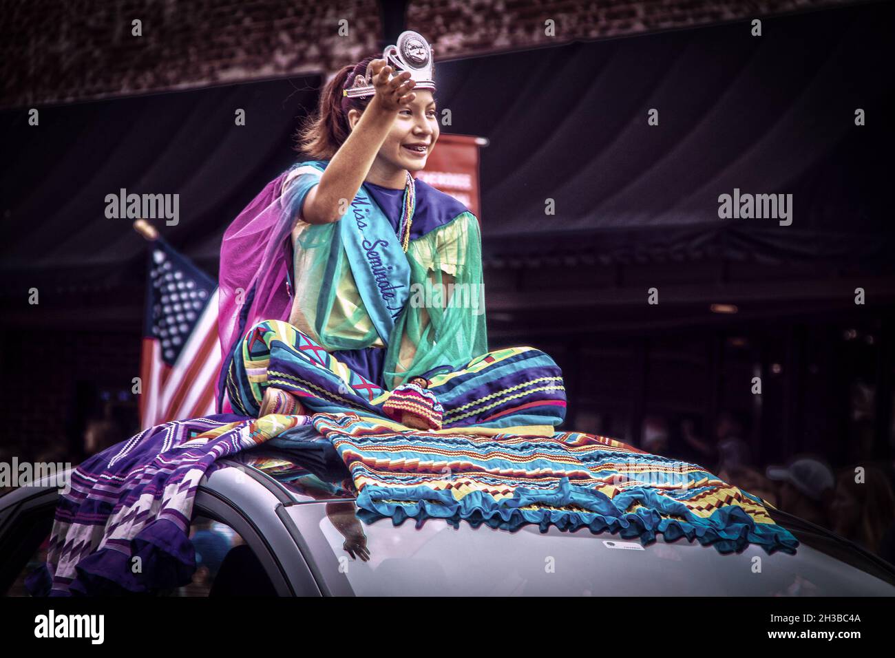 2019 08 31 Tahlequah USA Seminole Indische Prinzessin sitzt auf bunten Roben auf dem Auto in Cherokee Holiday Paragde an der Hauptstraße. Stockfoto