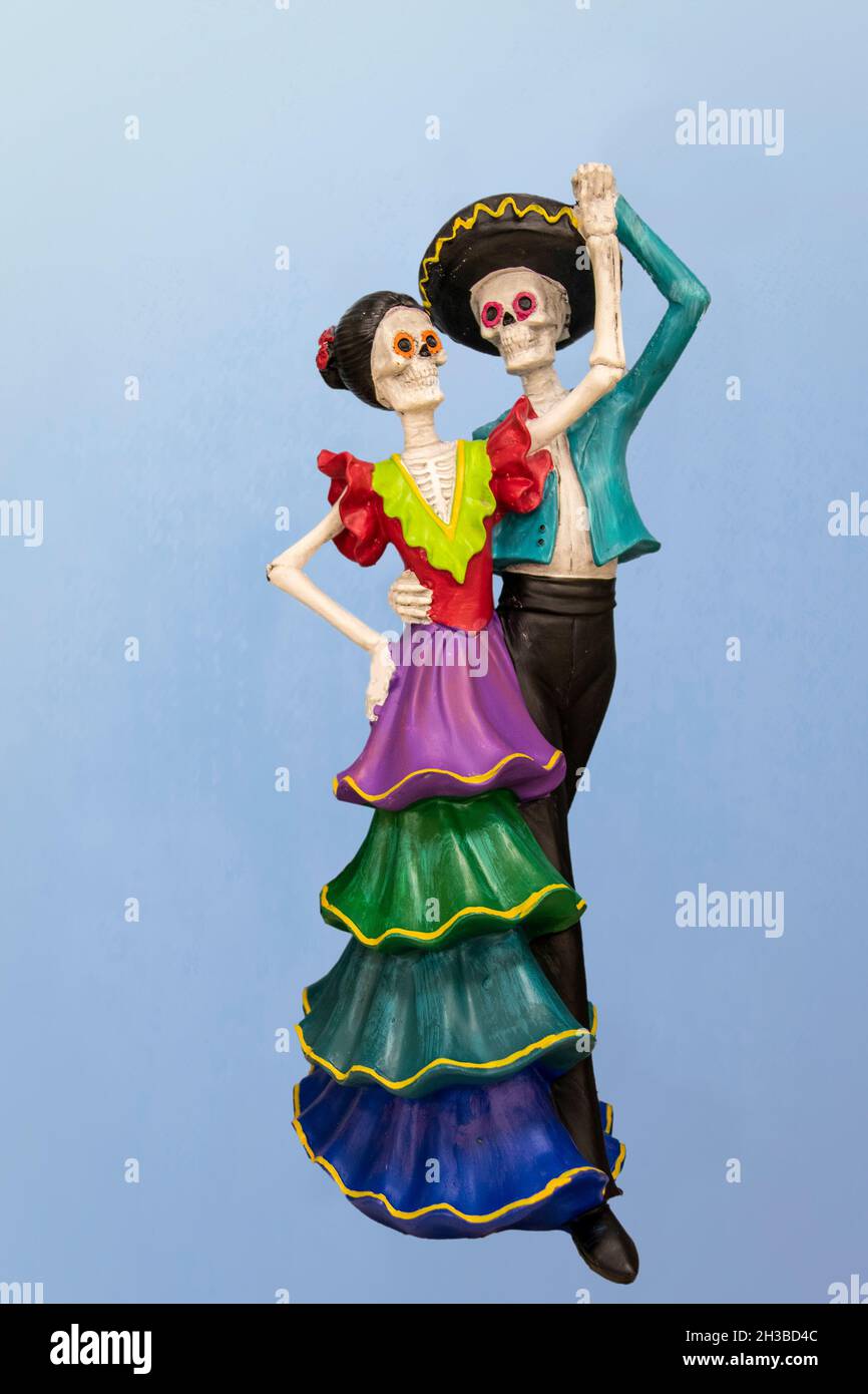 Dancing Dia la Muertos Couple - Keramik Dekoration - vor blauem Hintergrund. Stockfoto