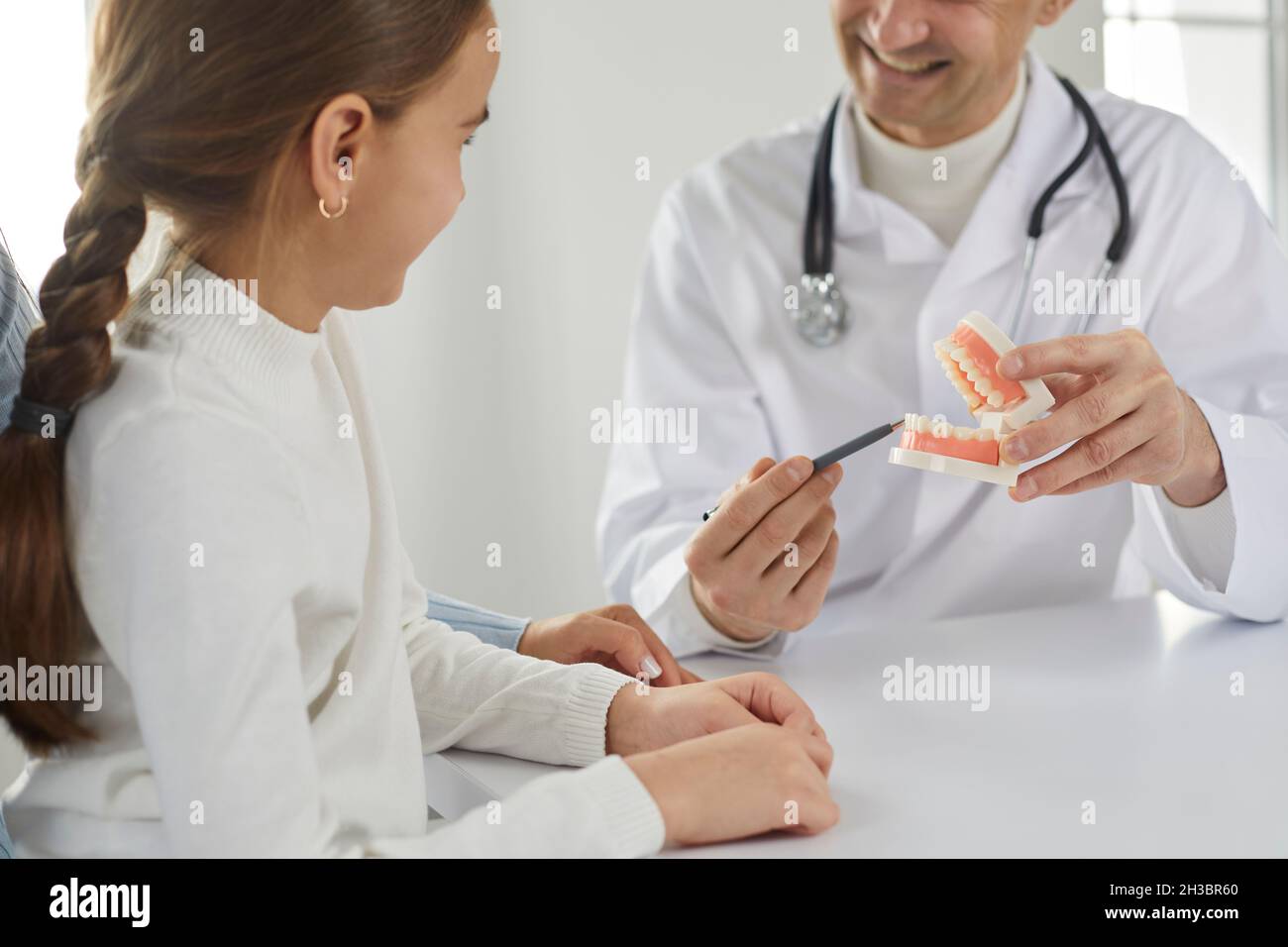 Lächelnder Zahnarzt im Krankenhaus mit einem Kind sprechen Stockfoto