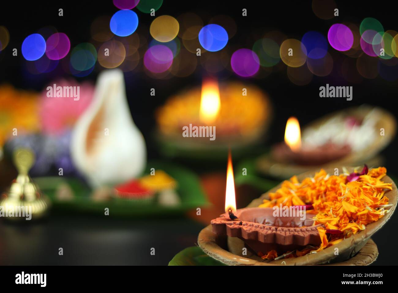 Diya oder Deep lit in Blattschüsseln auf Pattal oder Pattal Dona Katori, dekoriert mit Paan Shankh Roli Haldi und Blumen. Thema Für Diwali, Navratri Stockfoto