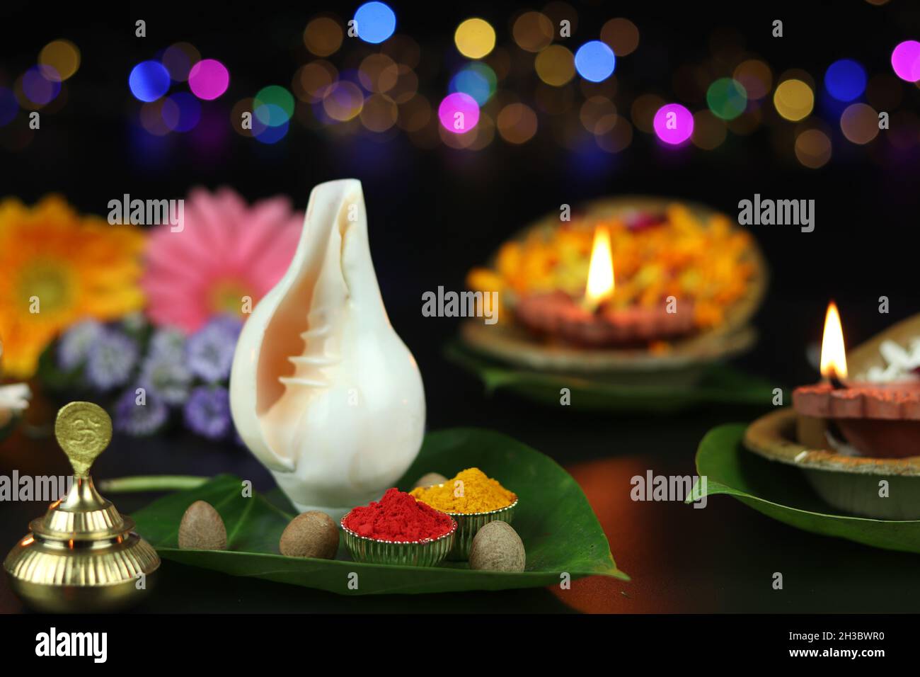 Zinnoberrot Roli Sindoor, Kurkuma Haldi Auf Betel Paan Blättern Und Shell Shankh. Tonöllampe Diya, Tief Oder Dia Im Hintergrund Beleuchtet. Thema Für Diwali, Nav Stockfoto