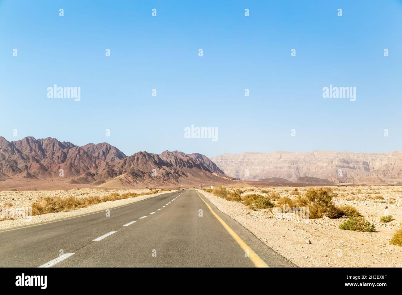 Straße in der Wüste, die bis zu den Bergen Timna offene leere Straße. Timna-Nationalpark. Stockfoto