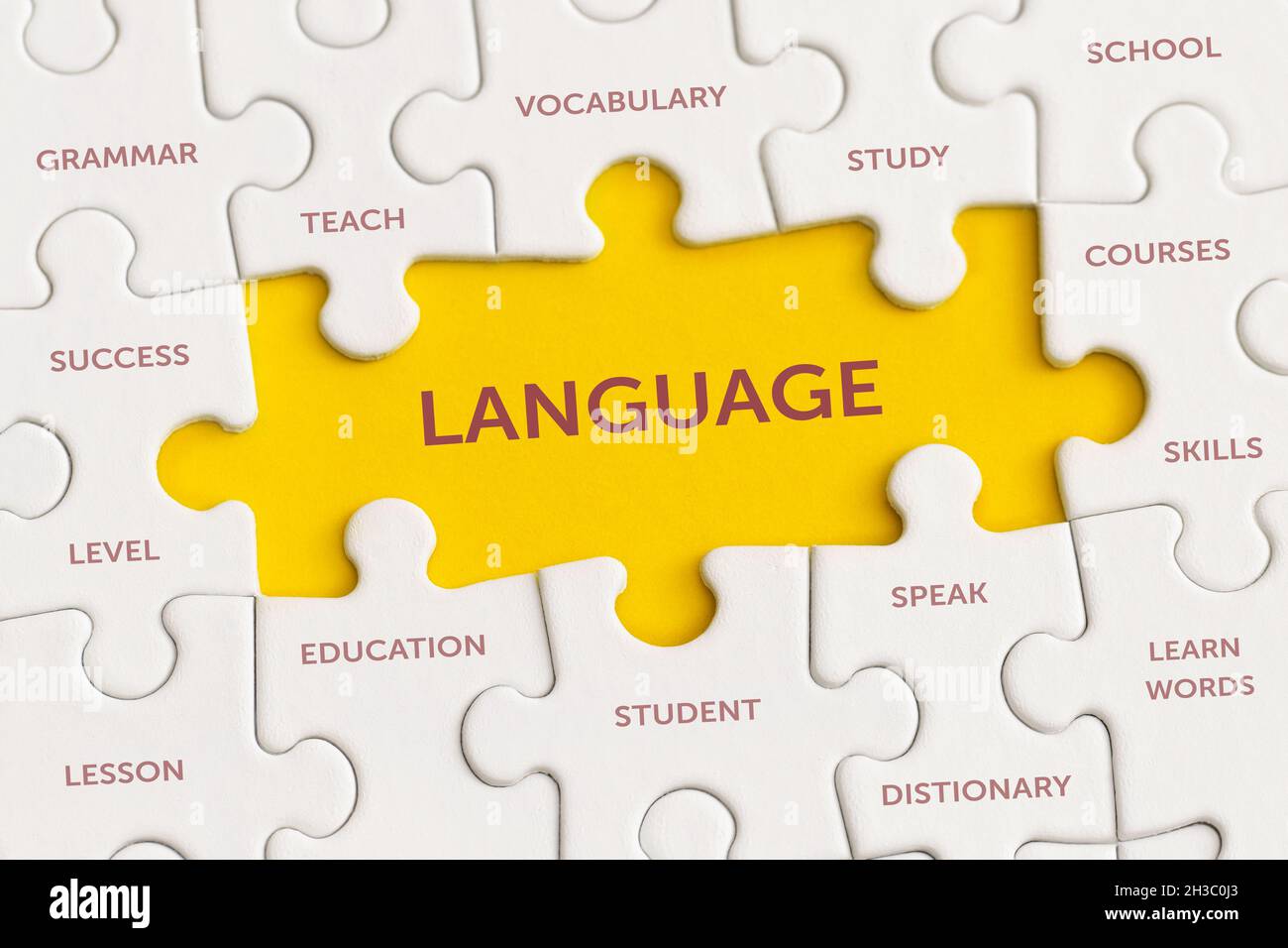 Weiße Details des Puzzles mit dem Text „Sprache“ auf gelbem Hintergrund. Stockfoto