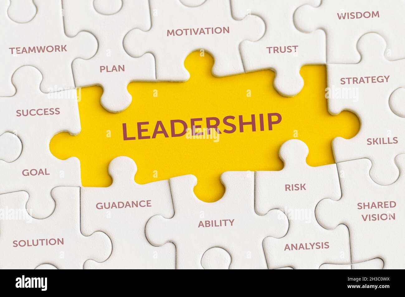 Weiße Details des Puzzles mit dem Text „Leadership“ auf gelbem Hintergrund. Stockfoto