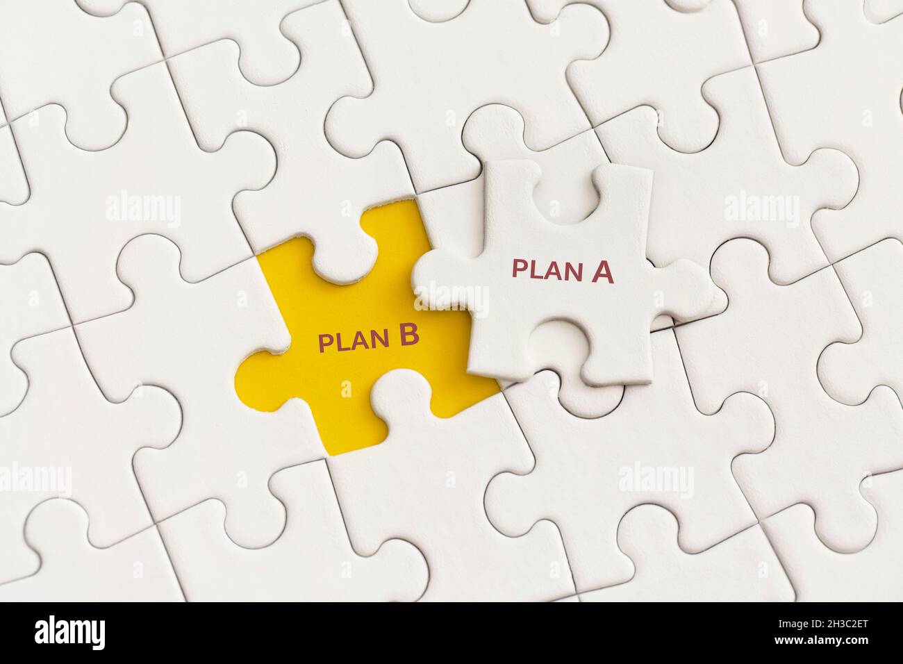 Weiße Details des Puzzles mit den Texten Plan A und Plan B auf gelbem Hintergrund. Stockfoto