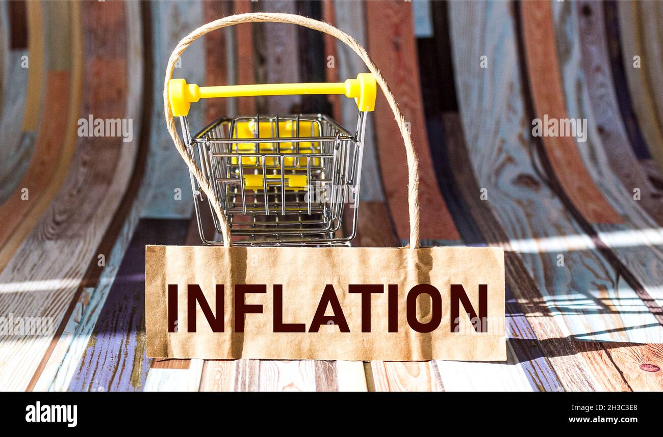 Das Wort Inflation auf dem Preisschild eines Geschäfts, das auf einem leeren Babywagen liegt Stockfoto