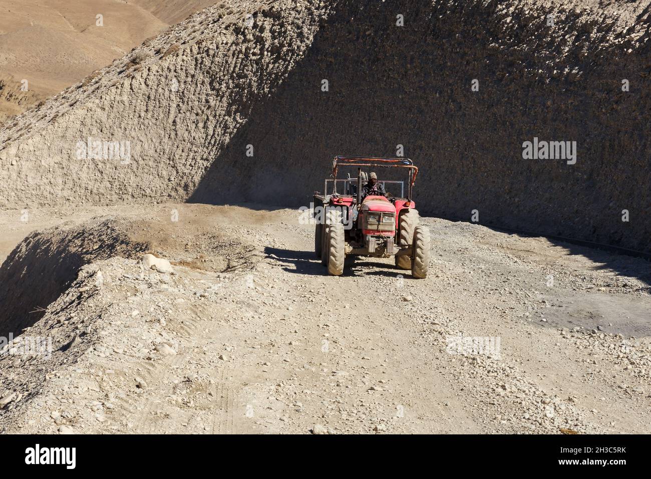 Kagbeni, Mustang District, Nepal - 19. November 2016: Der Traktor fährt entlang der Straße in den Bergen. Schotterstraße von Jomsom nach Muktinath in Stockfoto