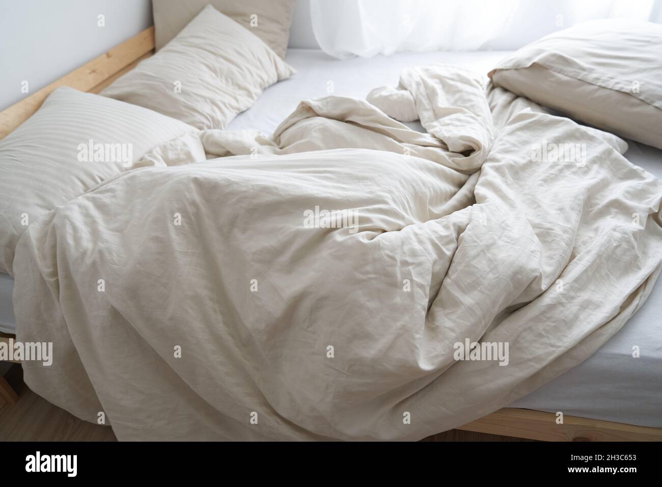 Ein Bett im Innenraum des Zimmers. Draufsicht. Das Bett ist nicht gemacht. Beige Farbe. Hochwertige Fotos Stockfoto