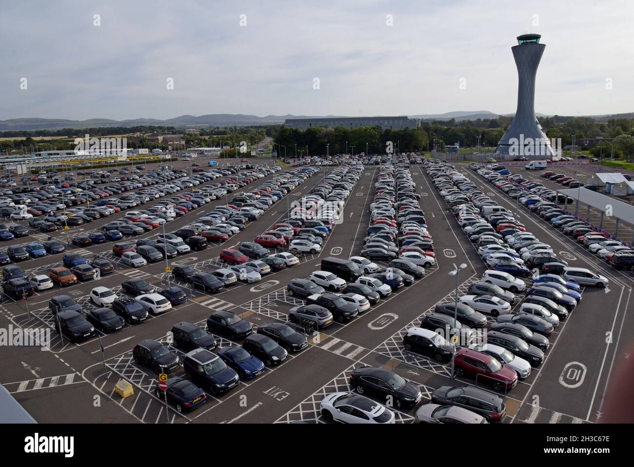Blick auf den Kontrollturm und ausgedehnte Flughafenparkplätze am Flughafen Edinburgh, Schottland. Stockfoto