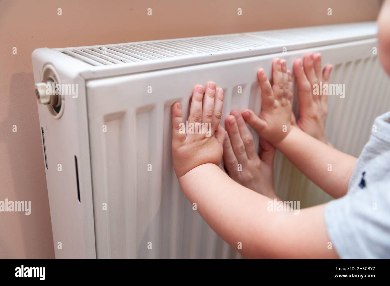 Lviv, Ukraine. Oktober 2021. Baby- und Erwachsenenhände spüren die Temperatur des Heizkörpers. In der Regel beginnt die Heizsaison in der Ukraine vom 15. Oktober bis 15. April oder unabhängig von jeder Zeit, wenn die Temperatur außerhalb unter 8C liegt. Kredit: SOPA Images Limited/Alamy Live Nachrichten Stockfoto