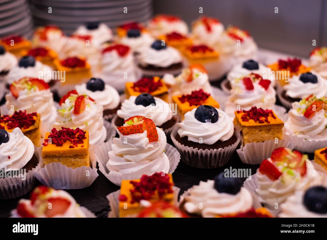 Kleine Kuchenauswahl. Orangenkäse-Kuchen. Pavlova mit Erdbeere. Schokoladenmuffin mit Mascarpone. Köstliches professionelles Essen und Snacks Catering. Stockfoto