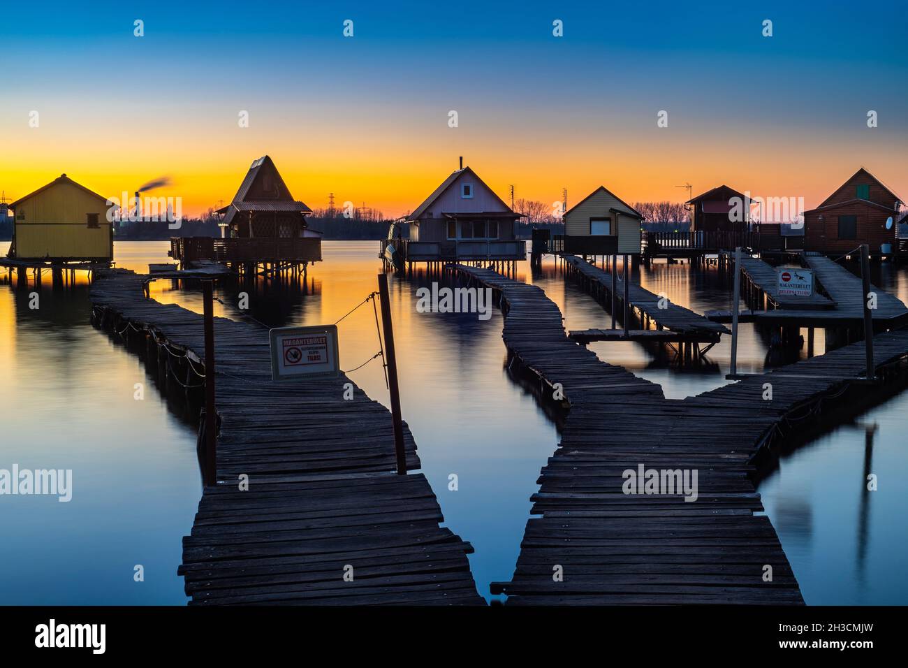 Schwimmendes Dorf am See Bokod während des bunten Sonnenuntergangs mit Reflexion, Ungarn Stockfoto