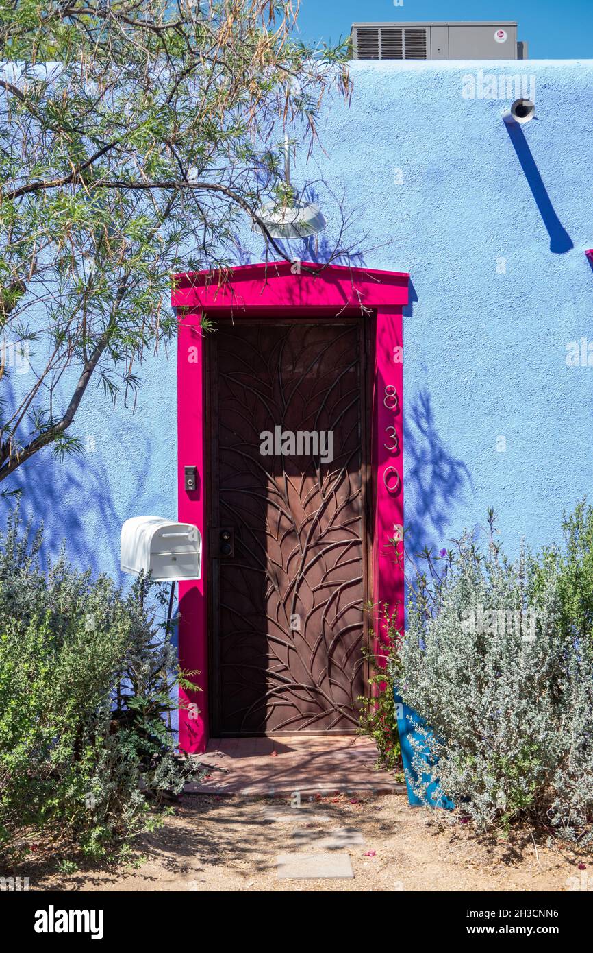 Eine leuchtend rosa Umrandung einer Tür auf einem babyblauen lehmziegelhaus in Barrio Viejo, Tucson, AZ Stockfoto