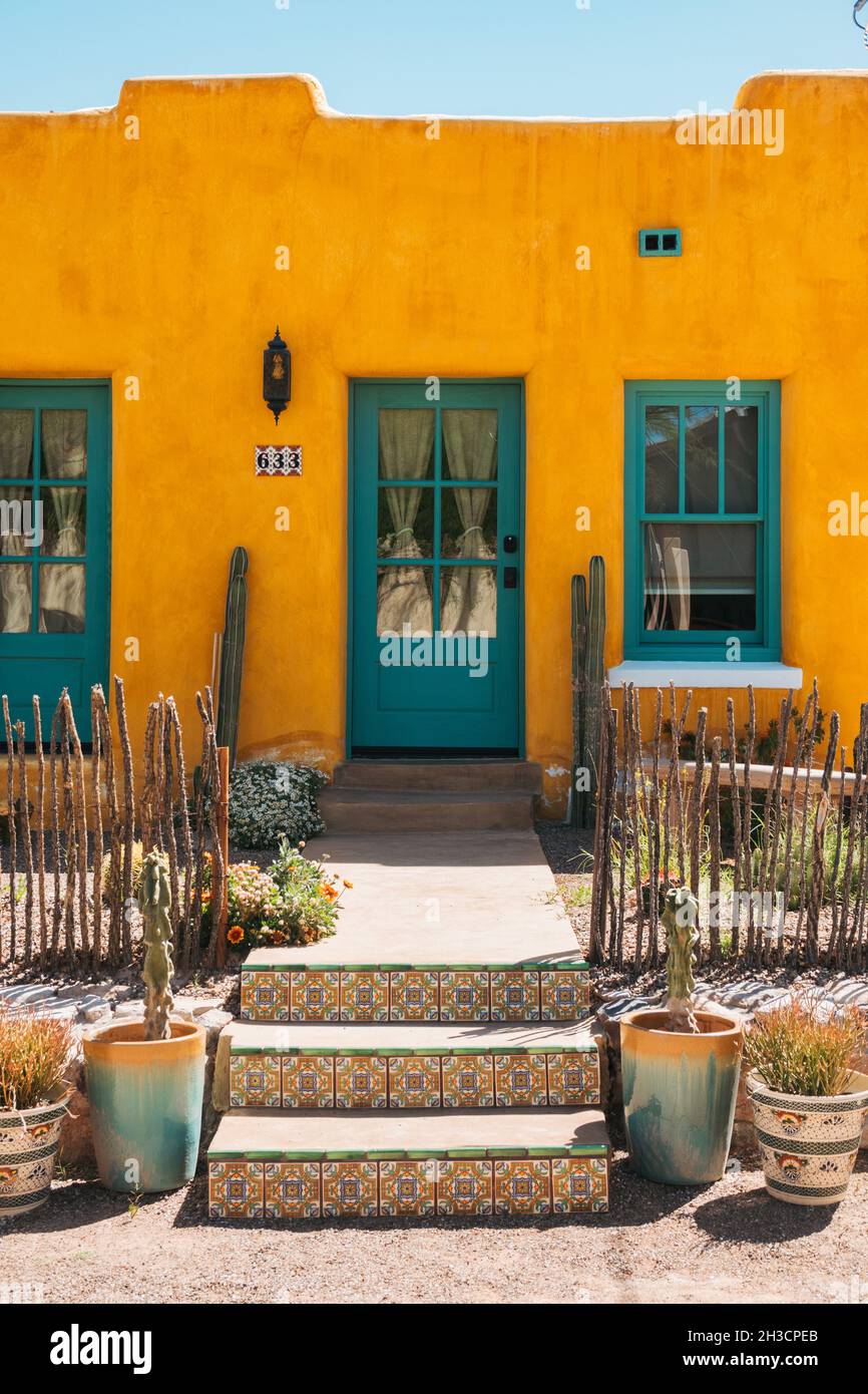 Ein verziertes, helles, gelbes lehmziegelhaus mit türkisfarbenen Türen und Fenstern in Barrio Viejo, Tucson, AZ Stockfoto