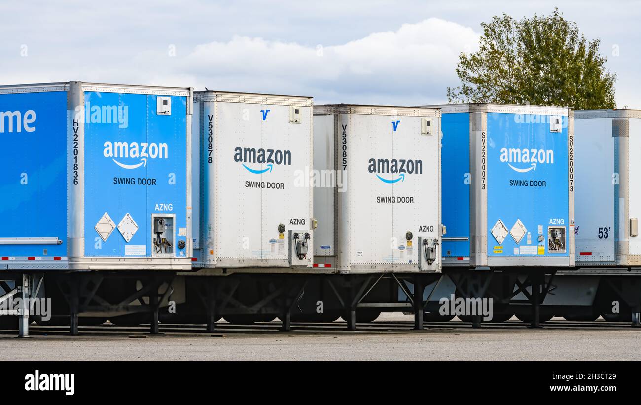Everett, WA, USA - 18. Oktober 2021; Linie von blau-weißen Versandanhänger mit dem Amazon-Logo und Flügeltürentext in Everett, WA, geparkt Stockfoto