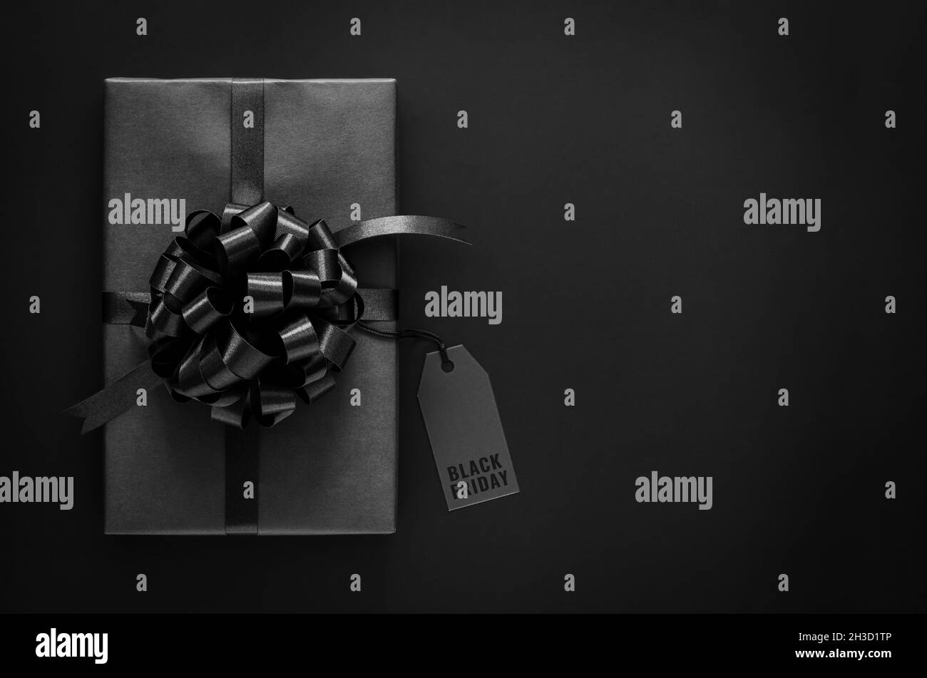 Eine Geschenkbox mit Band, die Preisschild mit Wort auf schwarzem Hintergrund haben. Black friday Konzept. Stockfoto