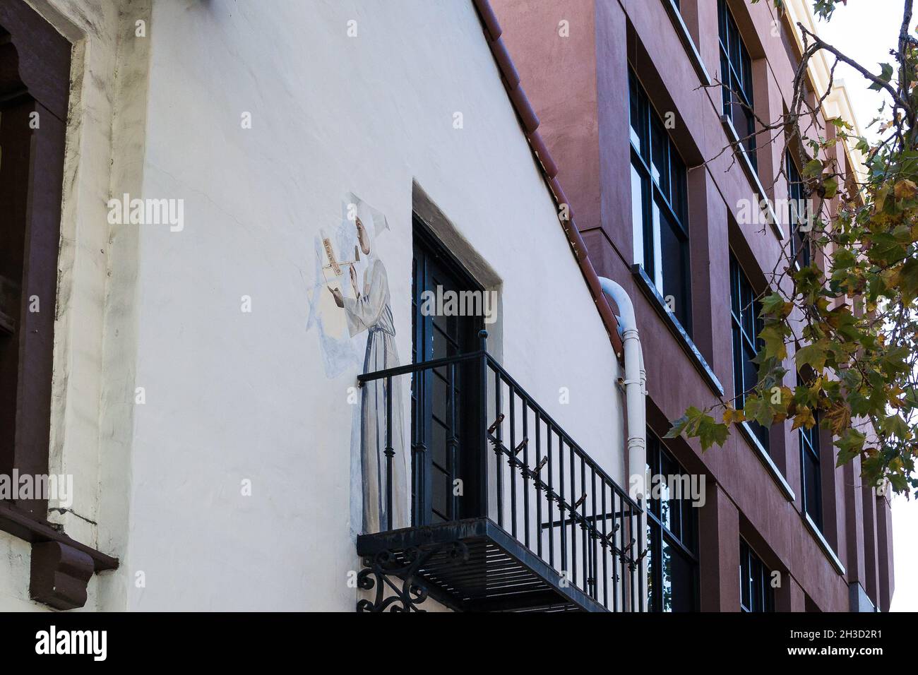 Das ortsspezifische Wandgemälde von Schwester Amelia, der Schutzpatronin der Flucht, die ein Papierflugzeug von einem Balkon in der 436 University Ave, Palo Alto, abstartete. Stockfoto