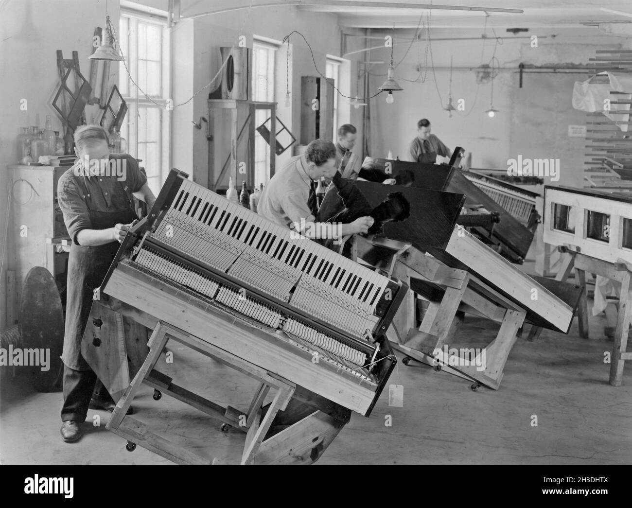 Klavierhersteller. Interieur vom schwedischen Hersteller von Klavieren und Flügeln Östlind & Almquist in Arvika. Arbeiter werden gesehen, wie sie die Holzarbeiten des Klaviergehäuses polieren, um sie glänzen zu lassen. Stockfoto