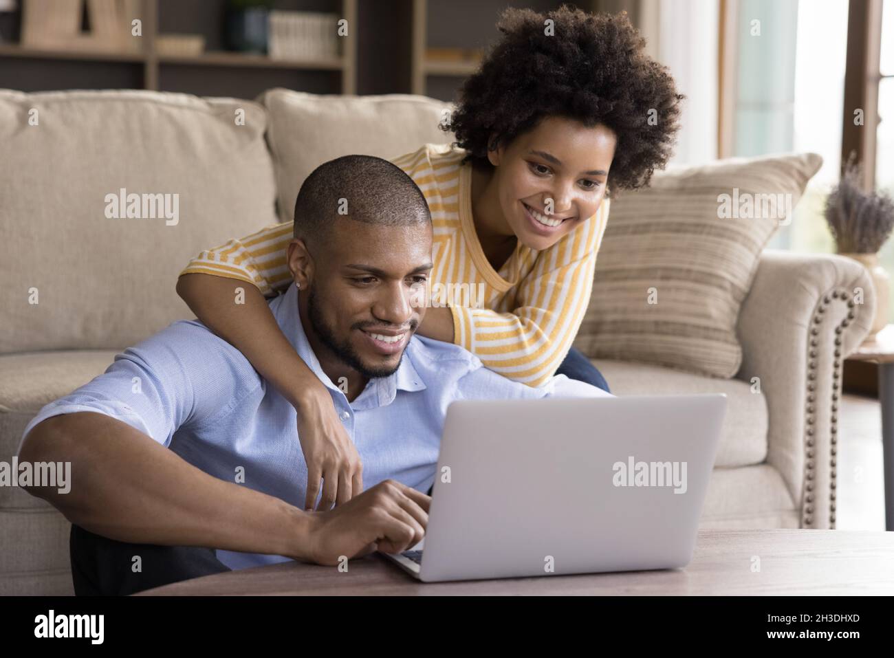 Glückliches junges afroamerikanisches Paar mit Computer. Stockfoto