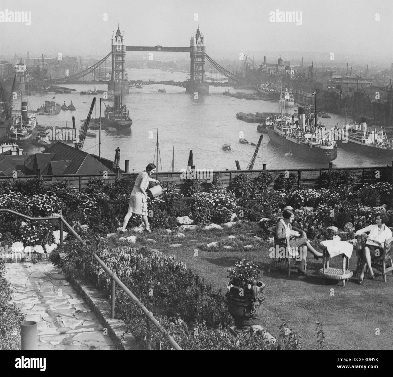 London in den 1930er Jahren. Blick über die Themse und die Tower Bridge vom Adelaide House. Im Vordergrund wird Tee serviert und auf der grünen Terrasse genossen. August 27 1935. Stockfoto