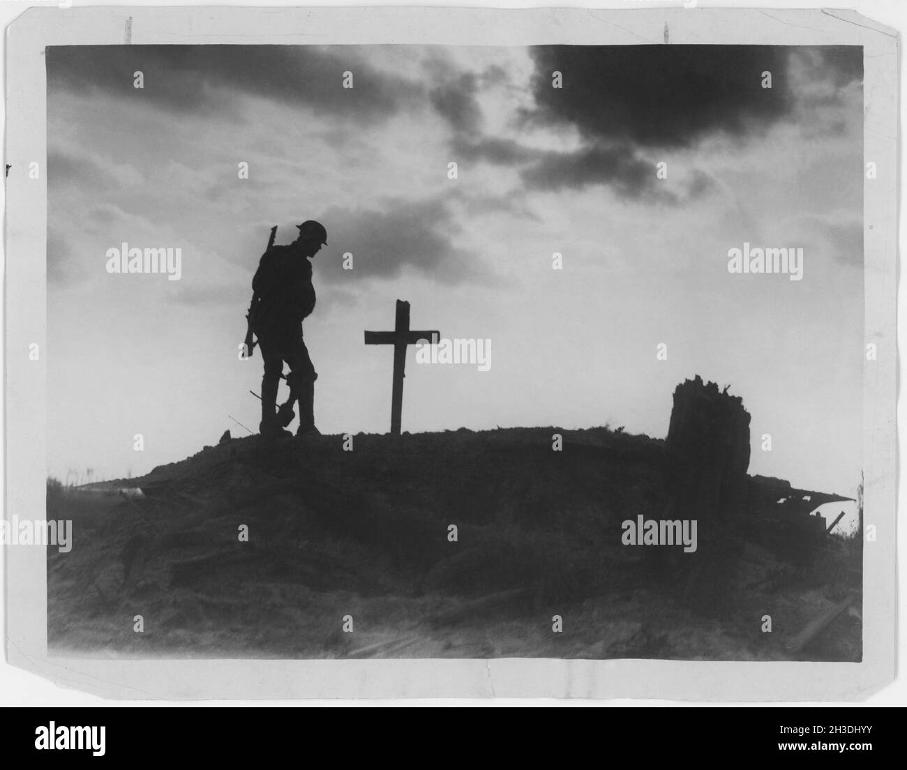 Erster Weltkrieg 1914-1918. Britischer Soldat und ein Grab mit einem hölzernen Kreuz in Silhouette auf einem Hügel. Erster Weltkrieg Stockfoto
