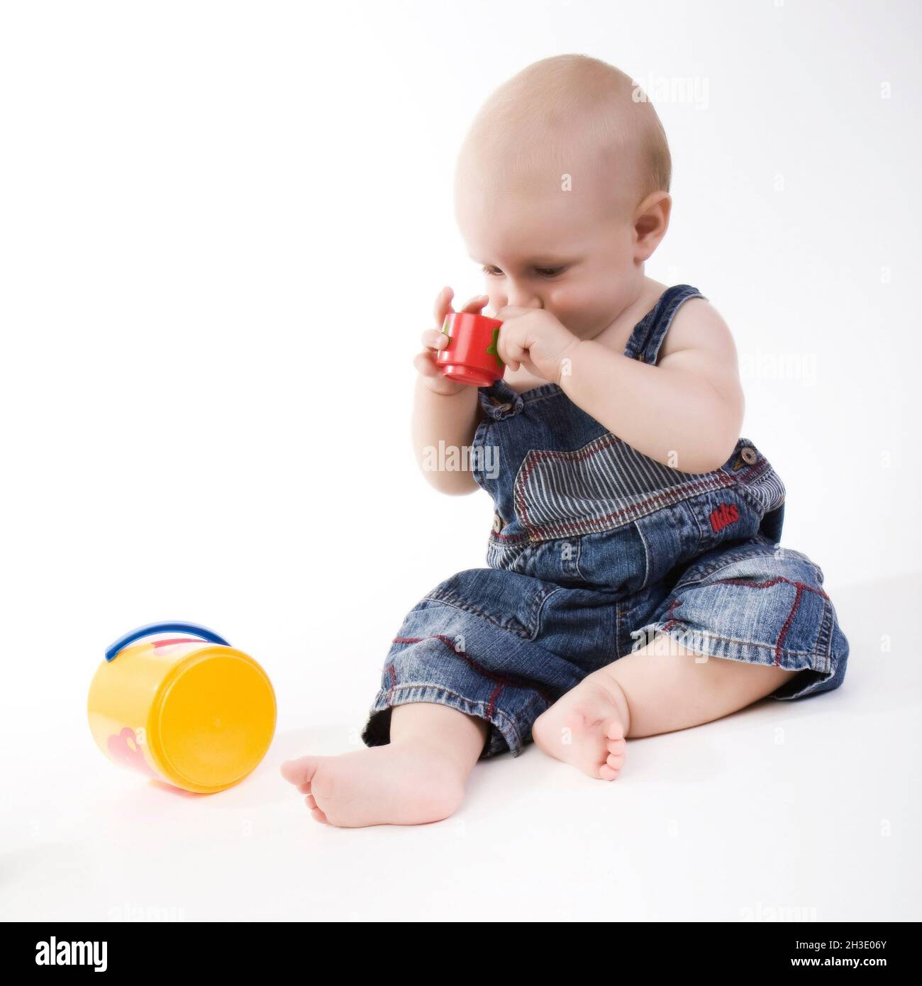 Baby spielt mit farbigen Eimern Stockfoto