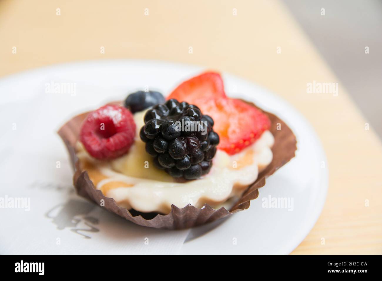 Obsttartlet mit Erdbeeren, Brombeeren und Himbeeren, serviert auf einem Teller Stockfoto