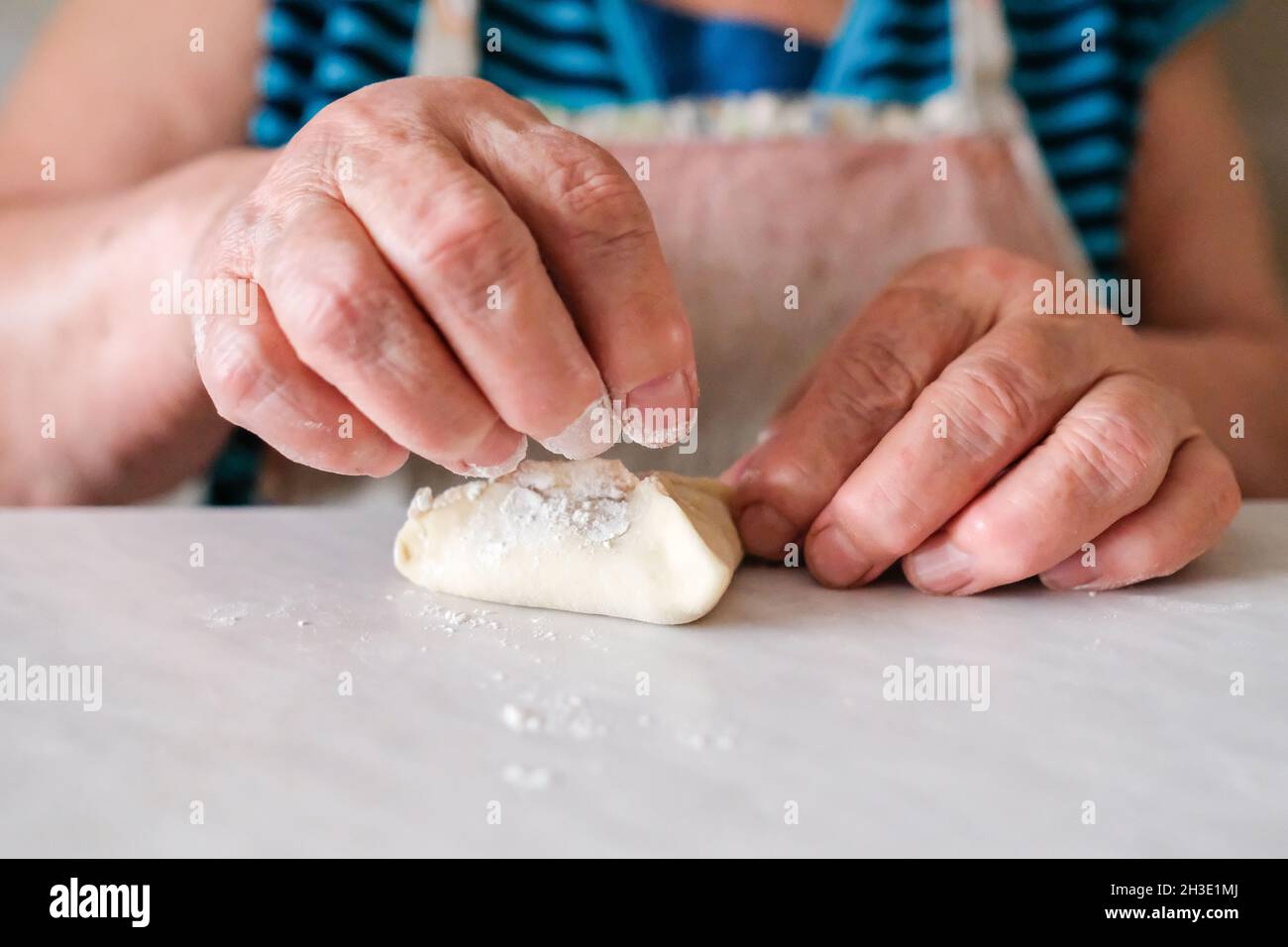 Zerknittert Omas Hände bereiten ein Gericht Teig vor Stockfoto