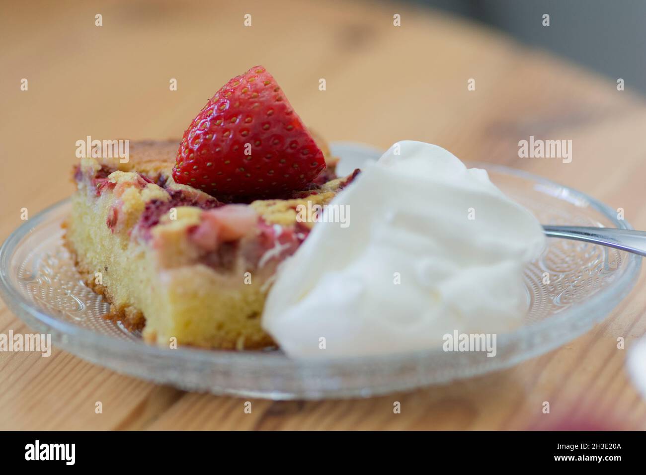 Eine Scheibe Erdbeerkuchen mit Creme, serviert auf einer Platte Stockfoto