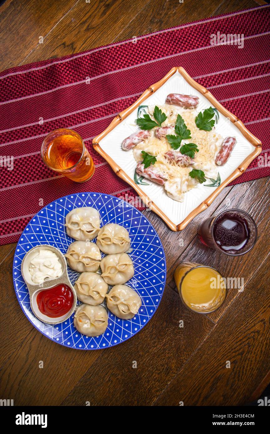 Pasta mit Wurst und Manti auf dem Tisch in einem Café. Draufsicht Stockfoto