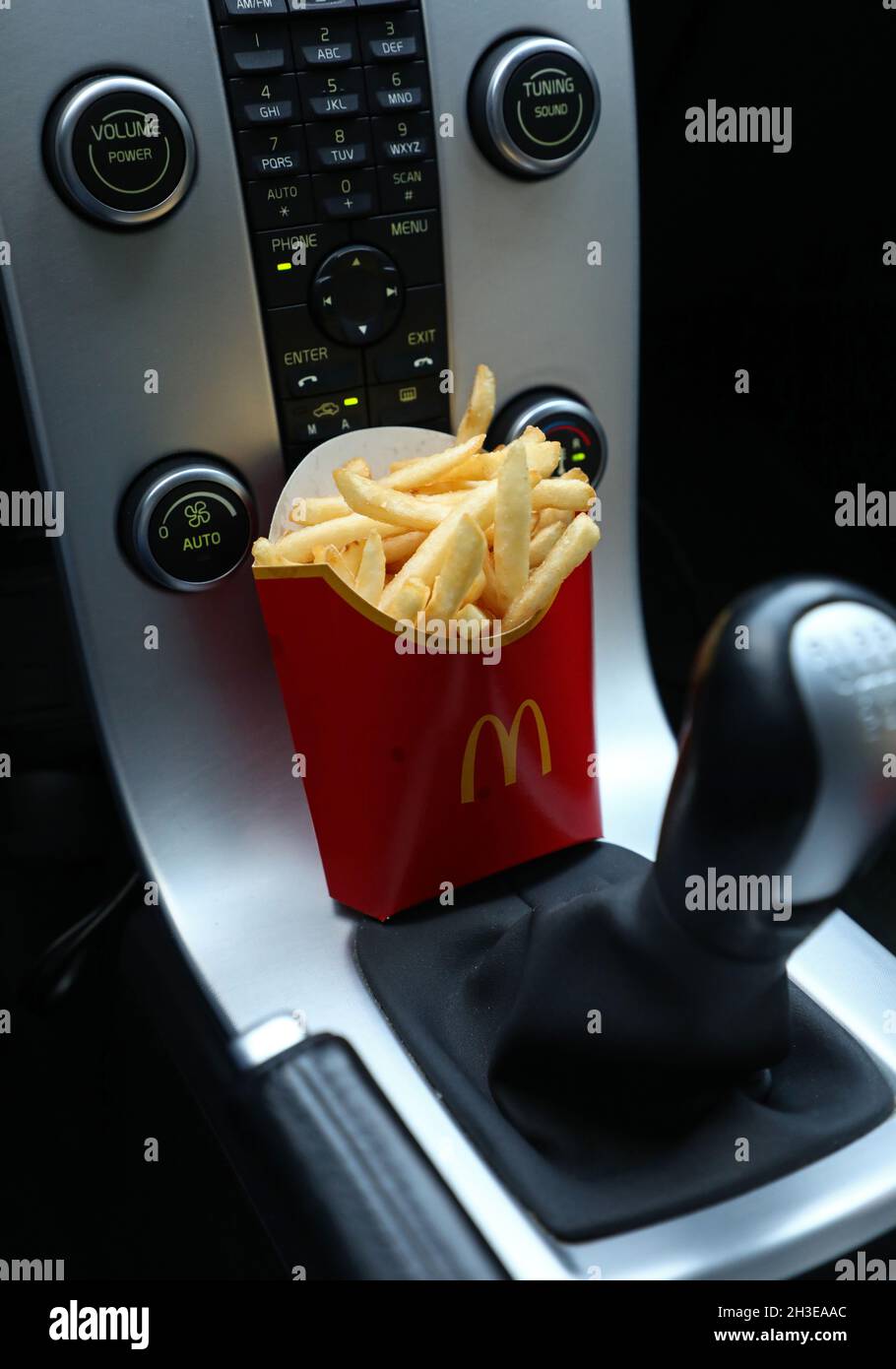 Ein McDonald's-Menü im Auto. Hier pommes Frites am Schalthebel. Stockfoto
