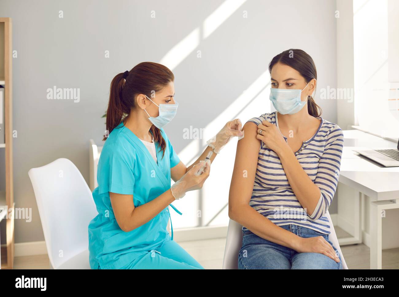 Arzt impfen weibliche Patienten gegen Corona-Virus Stockfoto