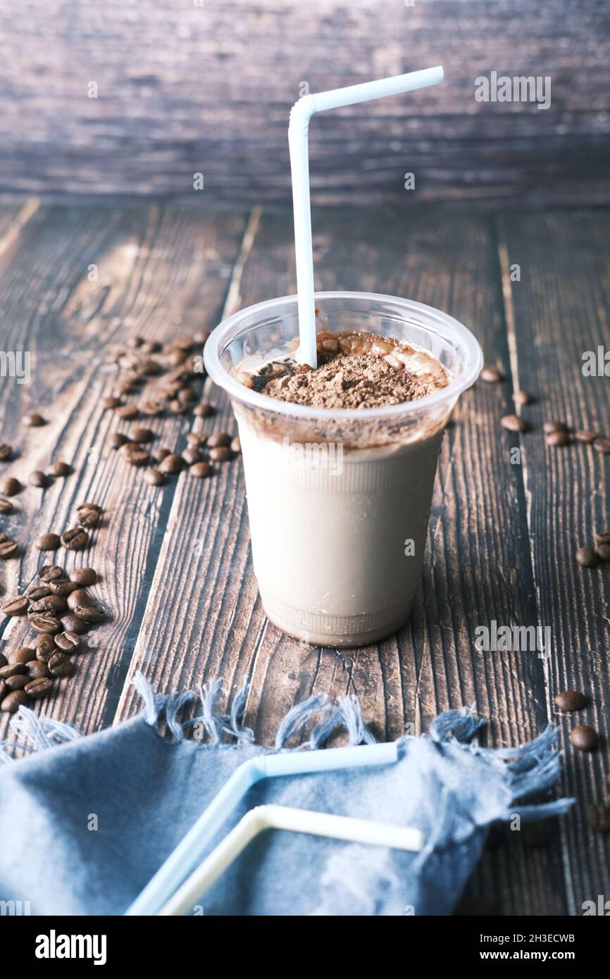 Eiskaffee in einem hohen Glas auf schwarzem Hintergrund. Stockfoto