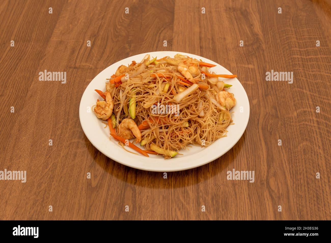 Chinesische Reisnudeln mit Garnelen und Gemüse im Wok und mit Sojasauce anbraten Stockfoto