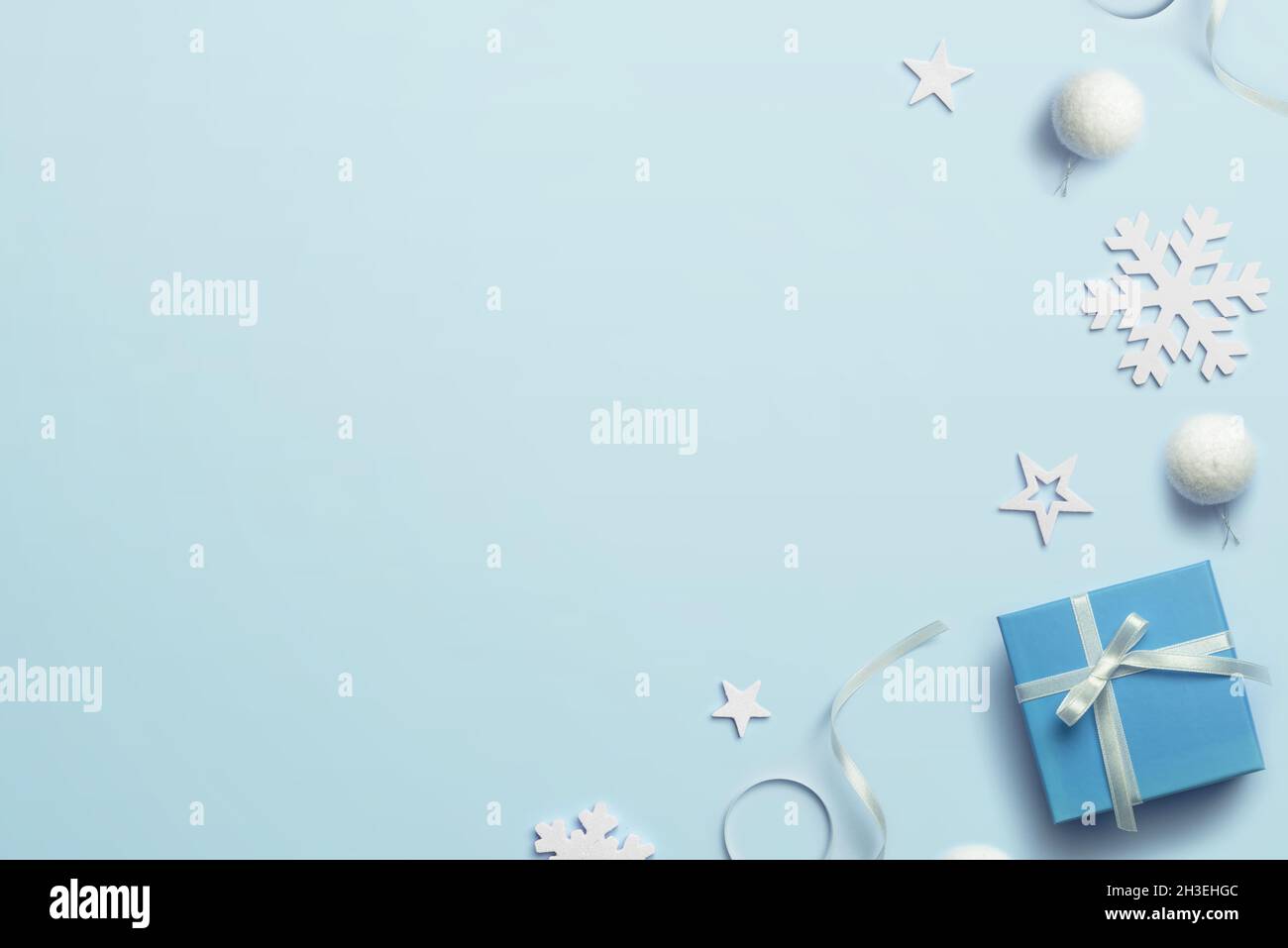 Blaue Weihnachten Hintergrund Komposition mit Geschenk und Dekorationen. Leerzeichen neben Grußtext kopieren. Draufsicht, flach liegend Stockfoto