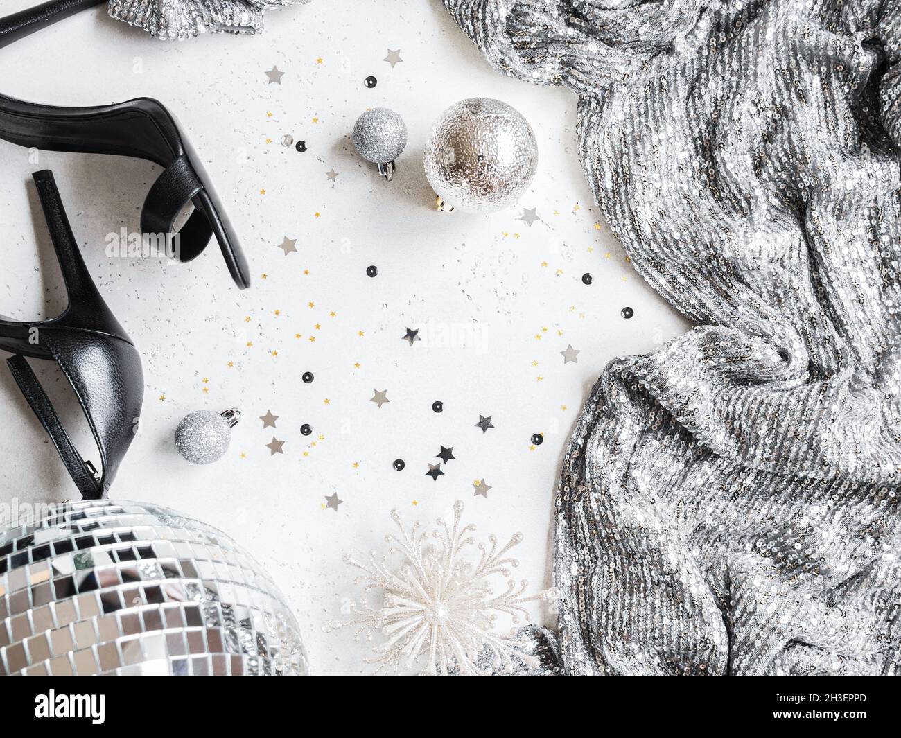 Flaches Lay von Weihnachten Party Disco Ball, schwarze Schuhe, Kleid, Saison Dekoration auf weißem Hintergrund. Draufsicht. Speicherplatz kopieren Stockfoto