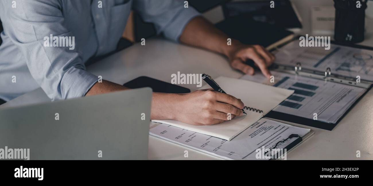 Nahaufnahme der Hand des Geschäftsmannes mit Stift schreiben auf Notebook. Männlich arbeiten für Business-Finanzanalyse Stockfoto