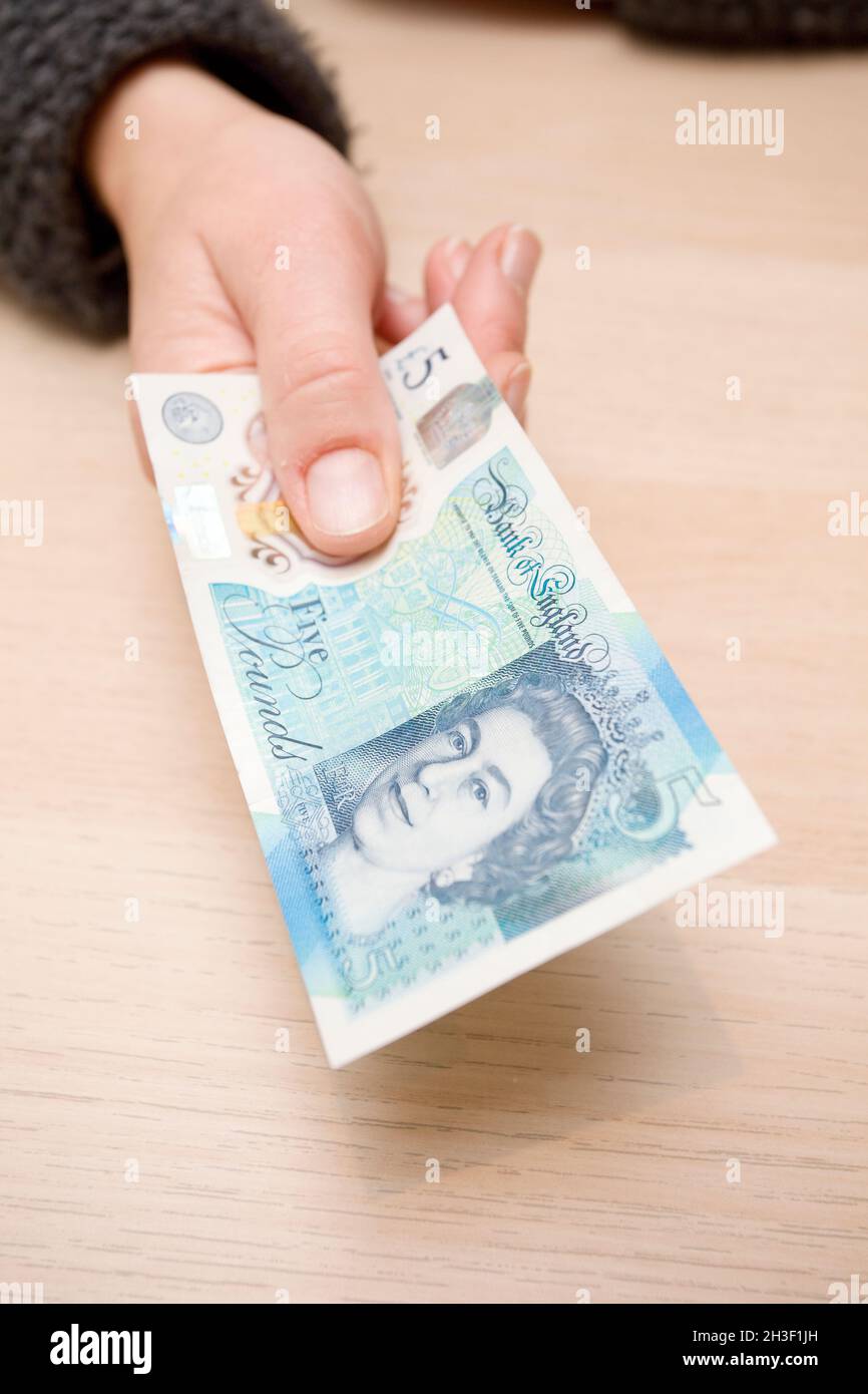 Fünf Pfund-Note in der Hand. uk Stockfoto