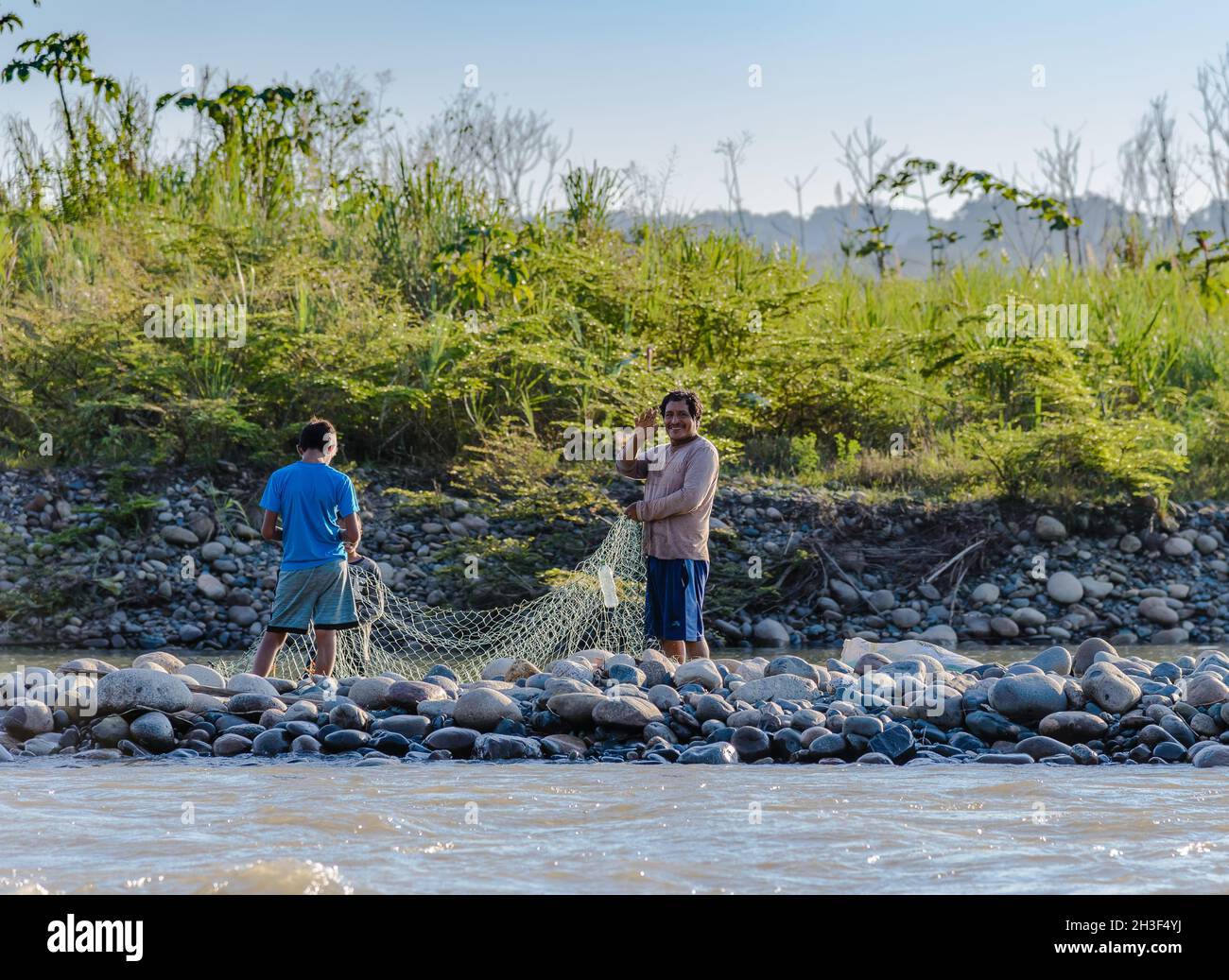 Ein einheimischer Mann und ein Junge, der am Fluss angeln. Rio Madre de Dios, Peru. Stockfoto