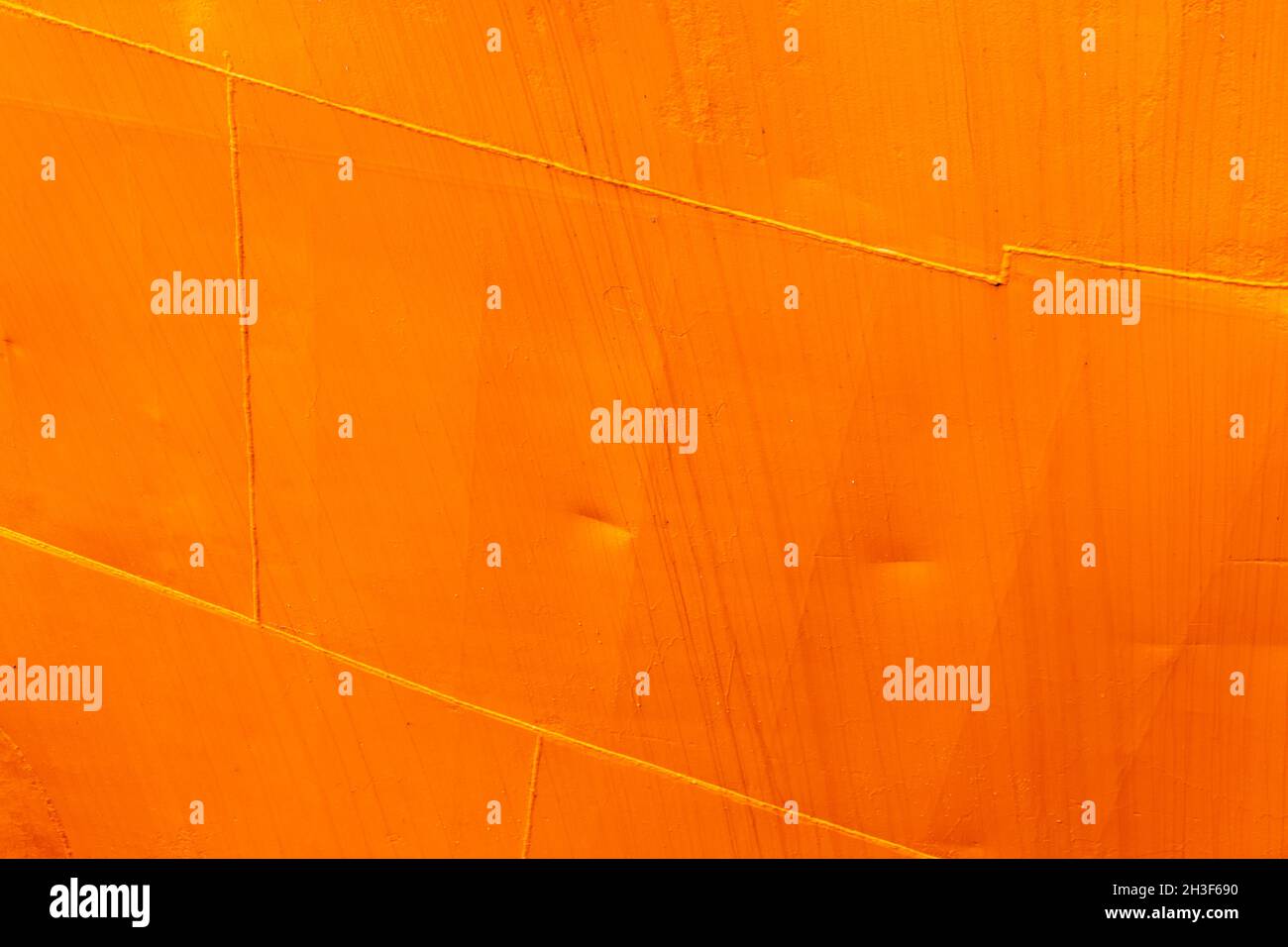 Fragment eines orangefarbenen Rumpfes eines Industrieschiffs, Metallbleche mit Schweißnähten, Hintergrundfotostruktur Stockfoto